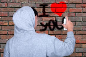 Una persona pintando graffiti en una pared.